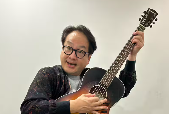ギターを弾く松浦真也